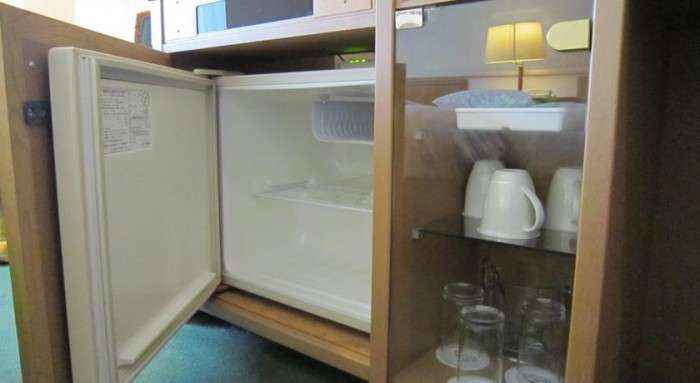 Tủ lạnh và ly, tách được sắp xếp gọn gàng, sạch sẽ.